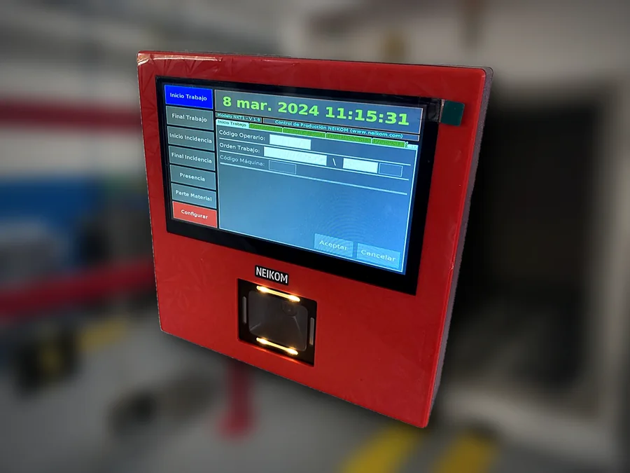 Terminal NKT1 de control de producción Terminal NKT1 de control de producción de Neikom con pantalla táctil y lector de código de barras, con una nave industrial de fondo