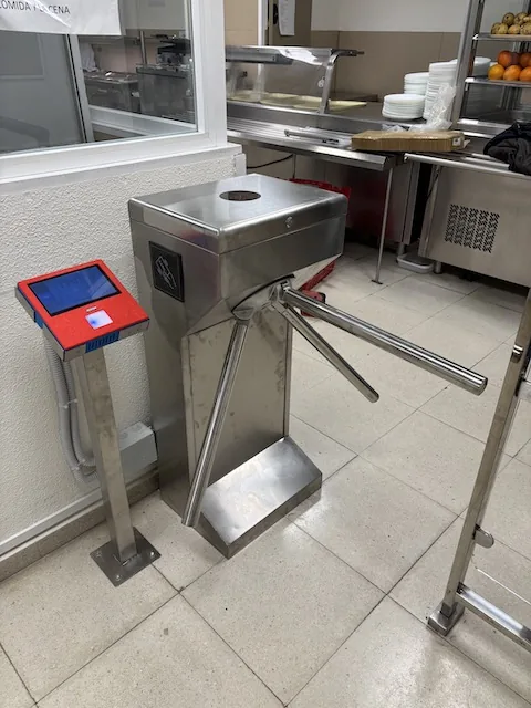 Control de acceso al comedor con torno Torno trípode de acero inoxidable con lector de tarjeta en la entrada del comedor de un hospital